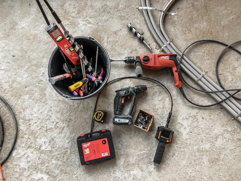 Elektrowerkzeug, Messgeräte und Kabel auf dem Boden einer Baustelle